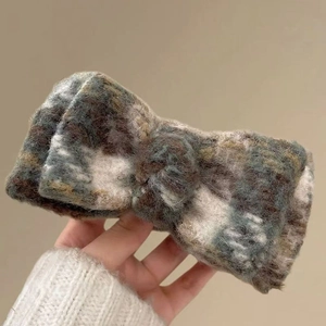 Close-up of winter plush plaid claw clip with warm mohair texture and a minimalist knot