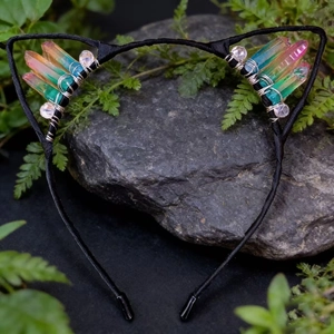 Detailed shot of handmade cat ear headband with rainbow crystals on a dark rock background