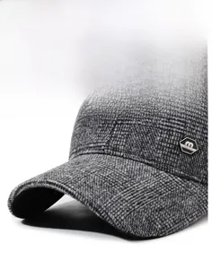 Detailed close-up of grey plaid baseball cap showing thick wool texture and metal logo