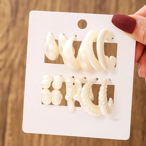 Detail view of a six-pair set of beige pearl-texture earrings in various geometric shapes
