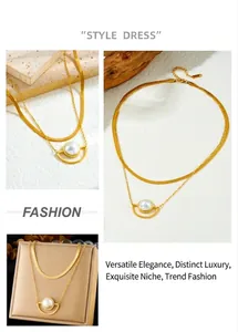 Detail of layered gold stainless steel necklace with flat snake chain and pearl pendant