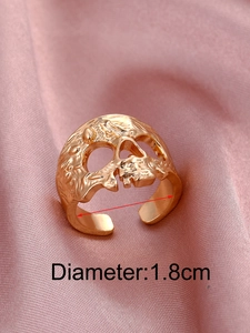 Dettaglio dell'anello teschio dorato che mostra il diametro di 1,8cm su sfondo di seta rosa
