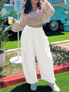 Outdoor shot of white linen wide-leg cargo pants with drawstring waist and side pockets