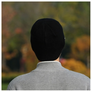 Detailed close-up of a black ribbed knit beanie showing high-quality elastic texture