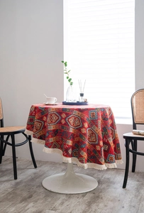 Close-up of round tablecloth with tribal geometric patterns and white fringe details