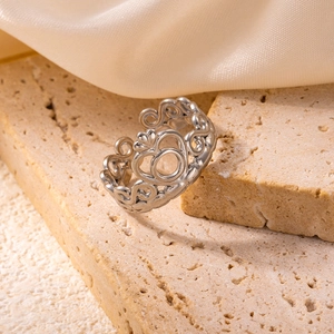 Macro shot of silver hollow crown ring detailing on a textured stone base