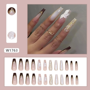 French tip press-on nails set with 3D leaf relief and gold chain accents in coffee and white