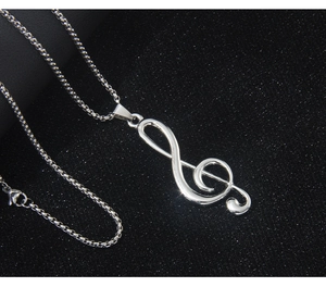 Macro shot of silver stainless steel treble clef pendant with a smooth box chain