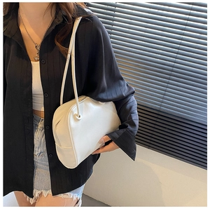 Detail of minimalist white tote bag featuring slim shoulder strap and sleek metal zipper