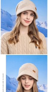 Detail of beige knit beret featuring a leather logo patch against a snowy mountain backdrop