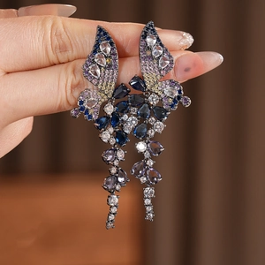 Vue détaillée des boucles d'oreilles papillon vintage avec pampilles en zircons colorés