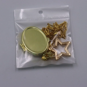 Golden oval locket pendant with star charm and chain inside a clear plastic storage bag