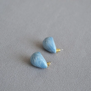 Detail showing light blue marble enamel texture on pear-shaped brass earrings
