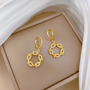 Detail of gold chain earrings with sparkling zircons placed on a jewelry box