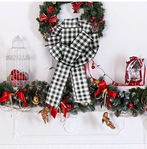 Classic black and white buffalo plaid Christmas bow hanging on a festive mantel wreath