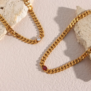 Macro view of 18K gold-plated 6.5mm Cuban link necklace with red and white zircons