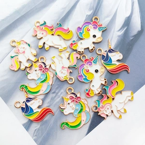 Detailed macro view of 10 gold alloy enamel unicorn pendants with rainbow hair and tails