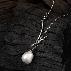 Twig necklace with baroque freshwater pearl on minimalist silver chain with rustic wood background