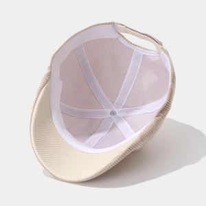 Detail view of corduroy baby cap interior showing six-panel stitching and adjustable strap
