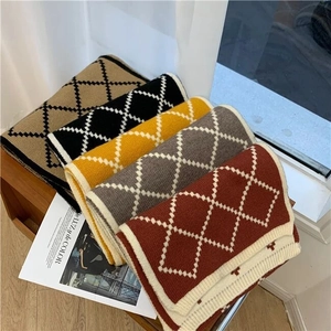 Detail showing five plaid knit scarves in camel black yellow grey and rust red colors