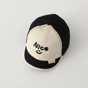 Detailed shot of Nice smile embroidery and yellow woven label on cotton baseball cap