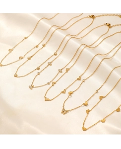Macro detail of gold plated heart and butterfly pendants on rippled silk fabric