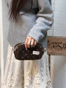 Detailed shot of brown sherpa pencil case with white polka dots and zipper closure