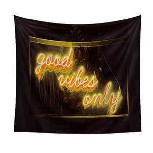 Detail of neon-style 'good vibes only' text on black wall tapestry with hanging loops