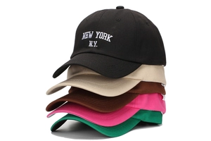 Détail de casquettes de baseball en coton empilées avec broderie New York en cinq couleurs