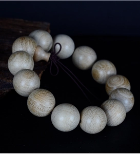Macro view of polished camphor wood prayer beads showing natural grain and rich texture