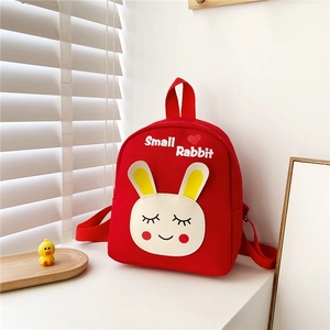 Close-up of red canvas kids backpack with cute white rabbit embroidery and top handle