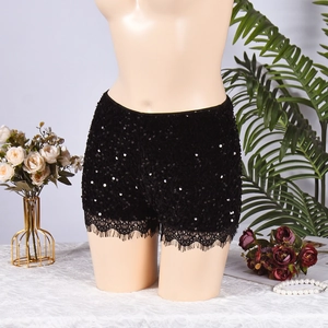 Détail du short à paillettes noires avec bordure en dentelle florale sur l'ourlet