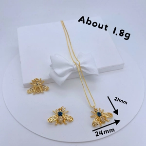 Collana con ciondolo a forma di ape in oro con pietre di zircone su base bianca