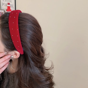 Detail view of retro red velvet headband with white pearl dots for elegant hair styling