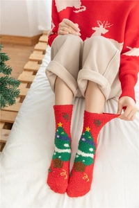 Detail of red coral fleece Christmas socks featuring a knit Xmas tree and plush texture