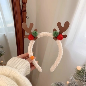 Detail of plush reindeer antler headband with festive red and green pompoms for Christmas
