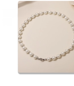 Macro detail of 12mm white pearls with silver spacers and a secure round metal clasp