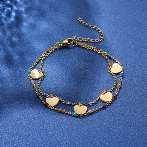Detail of double-layer gold chain bracelet with five heart charms and colorful beads