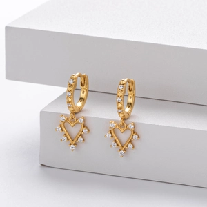 Macro detail of gold-plated heart drop earrings with sparkling zircon micro-paving