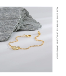 Vue macro détaillée du pendentif cœur plaqué or avec la lettre D gravée sur une chaîne fine
