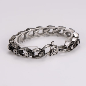 Detail of punk style skull link bracelet in vintage silver stainless steel finish