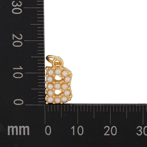 Detail of gold letter B pendant with pearls showing dimensions on a millimeter ruler