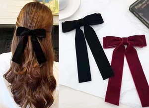 Detail of vintage velvet oversized bow hair clips in classic black and wine red colors