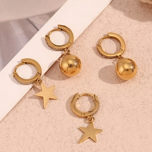 Close-up of 18K gold-plated star and sphere earrings with sparkling zircon inlay detail