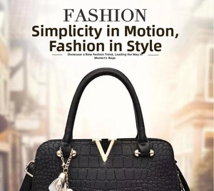 Detail of black embossed leather handbag featuring golden V metal logo and white charm