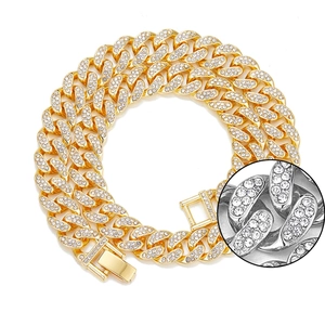 Detailed close-up of gold iced out Cuban link necklace with sparkling rhinestones