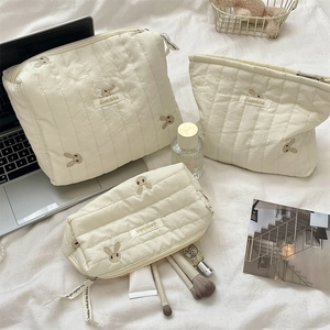 Detailed view of quilted cotton makeup bags with cute rabbit embroidery and brand logo
