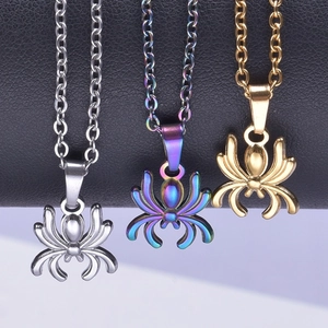 Three spider necklaces in silver, gold, and multicolor finishes on a dark leather backdrop