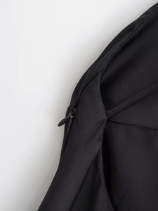 Detailed macro view of high-quality invisible zipper closure on black satin dress fabric