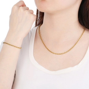 Close-up of elegant gold twisted rope chain necklace and bracelet set on a model
